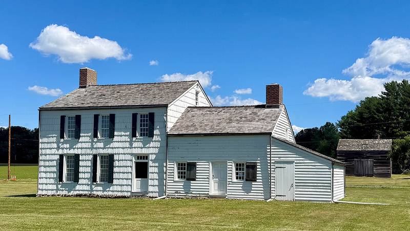 The white Craig House farmhouse and an old barn at Monmouth Battlefield State Park